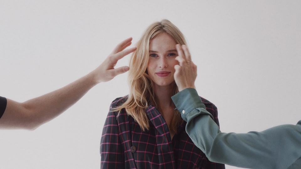 blonde female model facing the camera, getting styled by stylists