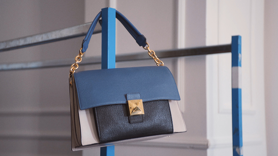 a blue, black and golden luxury bag hanging on wardrobe