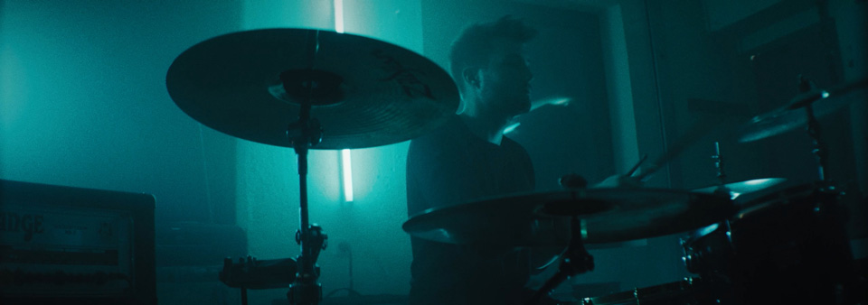 a drummer is performing in a dark basement