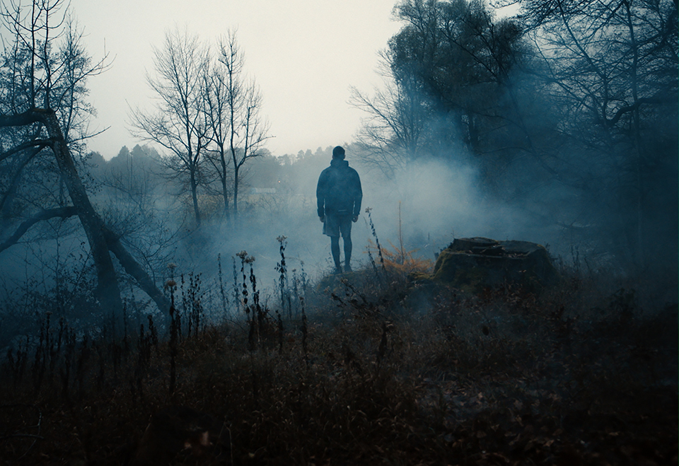man from behind in foggy forest