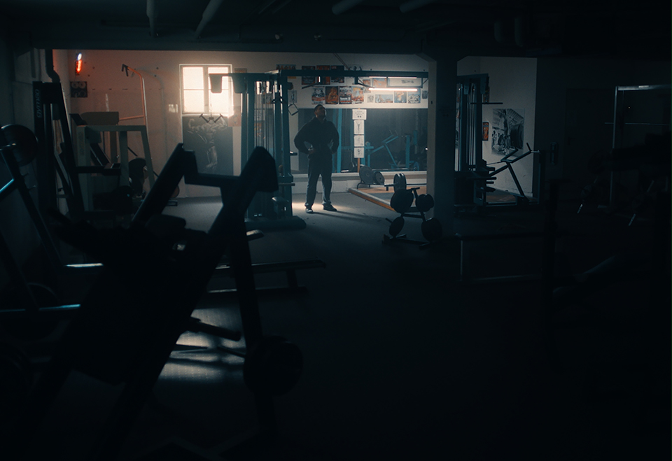lost in thought man standing lonely in dark gym