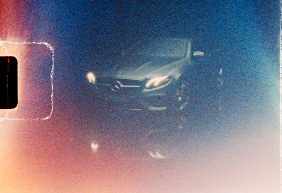 a silver Mercedes in a studio with grungy texture to mimic an old film camera