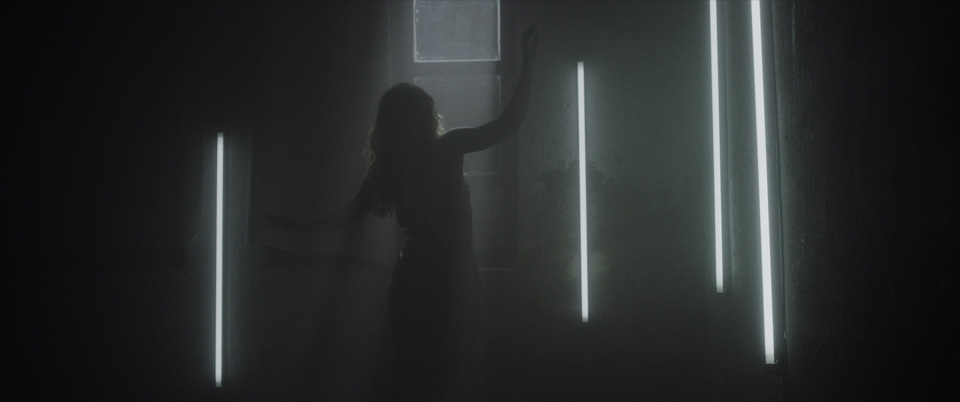 woman dancing inbetween white neon lights